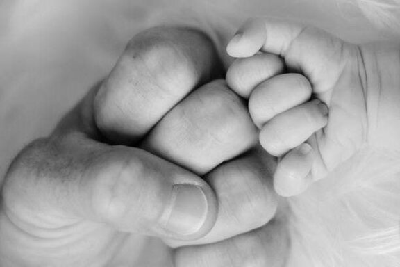 Erwachsene_Faust_mit_Baby_Faust ein Faustgruß eines Erwachsenen und eines Babys in schwarz-weiß