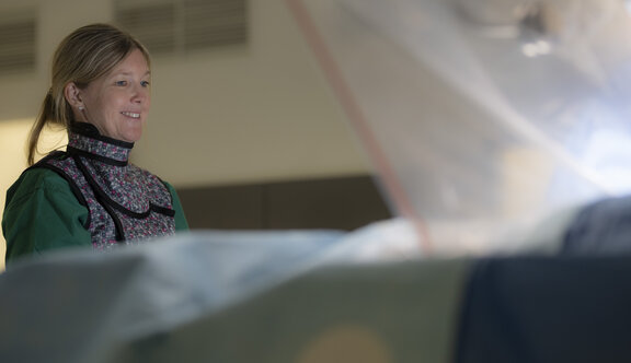 Pflegerische Leitung steht vor der OP-Liege und schaut nach unten