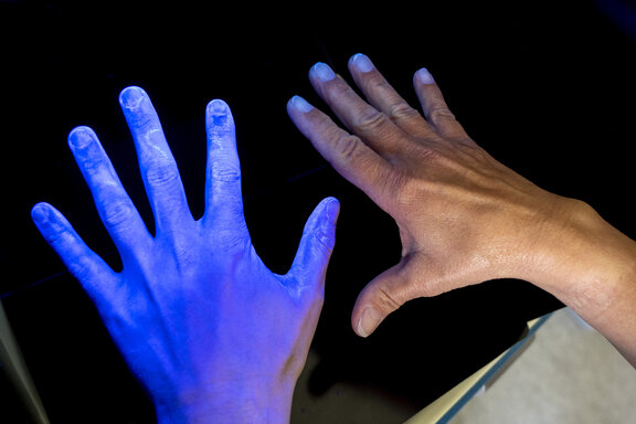 UV Bild von Händen, um die Handhygiene zu verdeutlichen. 