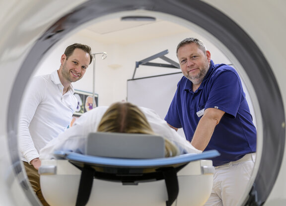 Dr. med. André Krämer und Dr. med. Steven Bellm führen eine MRT Untersuchung mit einer Patientin durch. Das Foto ist aus dem MRT entstanden.