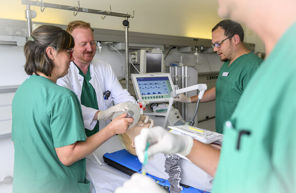 Dr. Tom McCracken und sein Team führen eine Simulation durch, in der ein Patient beatmet wird. alle schauen konzentriert auf den Übungspatienten.