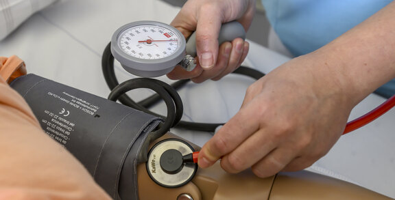 Blutdruckmessung an einer Patientensimulation. 